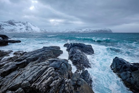 Waves of Norwegian sea crushing at rocky coast in fjord. Vikten