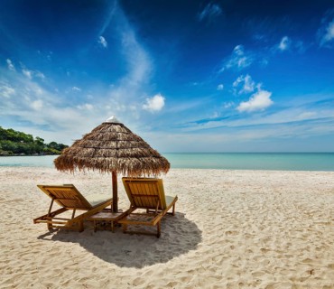 Two beach lounge chairs under tent on beach. Sihanoukville
