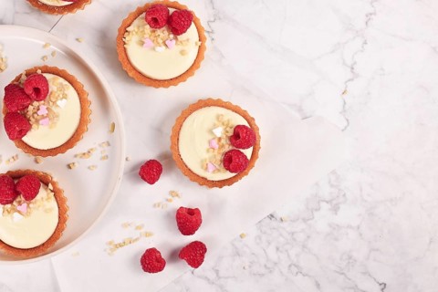 Top view of small tartlet pastries with white cream
