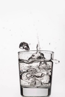 Crystals of ice falling into the glass of water