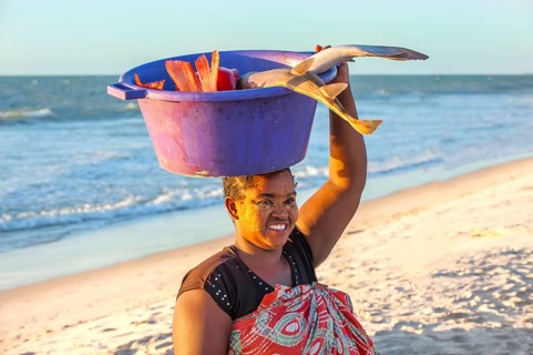 Malagasy woman carrying fish in a bowl on her head