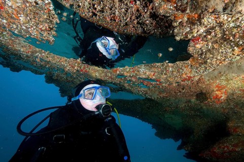Diver reflected in bubble in a cave
