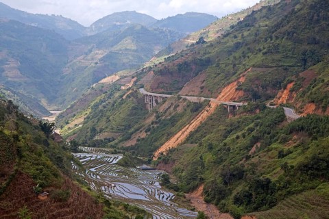 Chinese motorway and terraced rice paddies on the hillside in Yunnan Province