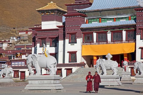 Two monks in front of the Tibetan monastery Sershu Dzong in Sershu village