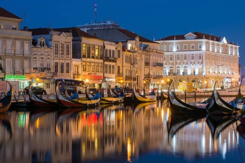 Gondola-like Moliceiros boats anchored at night on the Central Canal