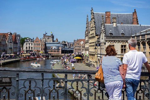 Tourists look from St. Michael's Bridge at the medieval houses along Graslei