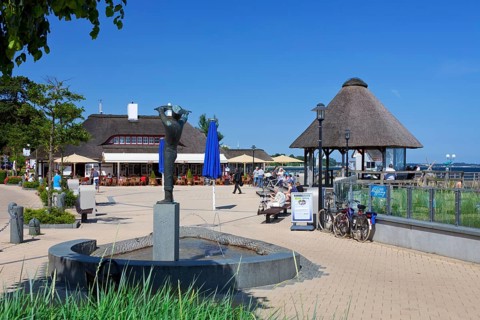 Statue and cafe-restaurant on the promenade in the seaside resort of Haffkrug