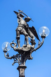 Lantern post with statue of Archangel Michael slaying Satan as a dragon at Saint Michael's Bridge in Ghent