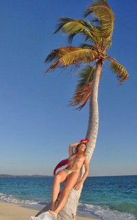 Woman leaning against coconut palm