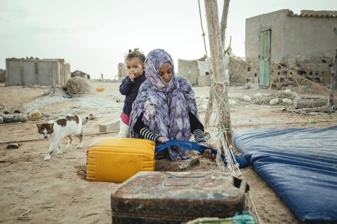 Woman filling drinking water into a canister