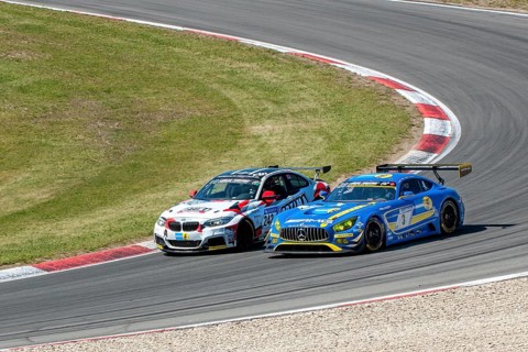 BMW M235i Racing is overtaken on the outside by Mercedes-AMG GT3 at 24h Nuerburgring race track 24-hour race