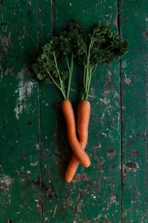 Two carrots bent into each other with parsley