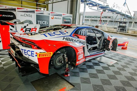 Racing car Lamborghini Huracan GT3 with wheels dismounted without tyres with visible brake disc stands in pit of pit lane at Nuerburgring race track