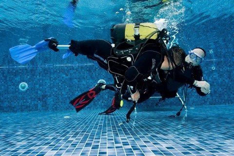 Disabled diver with prosthetic legs and diving instructor