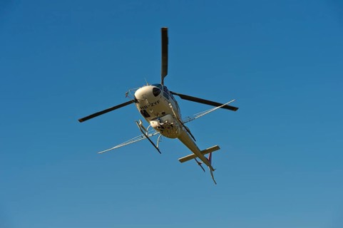 Helicopter Eurocopter AS350 B2 Ecureuil of Air-Glaciers SA with mounted spraying rods in flight