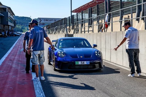 Blue Porsche 911 992 GT3 at trackday awaits clearance from race marshal to exit pit lane onto circuit
