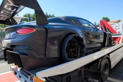 Bentley GT3 race car is taken back to Pit Lane of circuit by tow truck with punctured right rear tyre