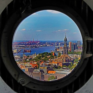 City view with the Michel and the harbour through the porthole windows in the spire of the main church St. Petri