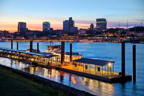 Pier for the harbour ferries at the Stage Theater on the Elbe in the evening in front of the city skyline