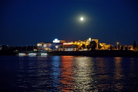 Atmospherically illuminated Stage Theater with the Elbe in the evening with full moon