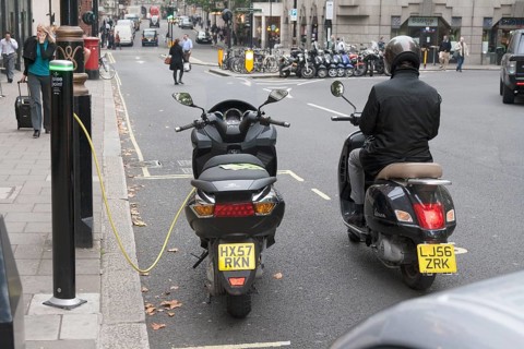 Motorist waiting to recharge his scooter