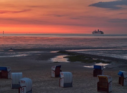 Beach chairs in the late evening on the beach of Cuxhaven with a view of the Elbe estuary