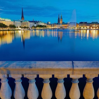 Inner Alster with Alsterfontaine and city skyline in the evening
