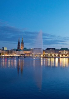Inner Alster with Alsterfontaine and city skyline in the evening