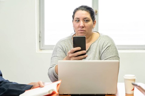 Mature business woman sitting at head of table in office meeting room