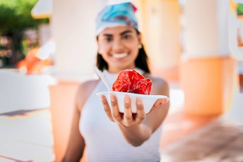 Close up of young woman holding a shaved ice in the street. Concept of a girl with a Nicaraguan raspado
