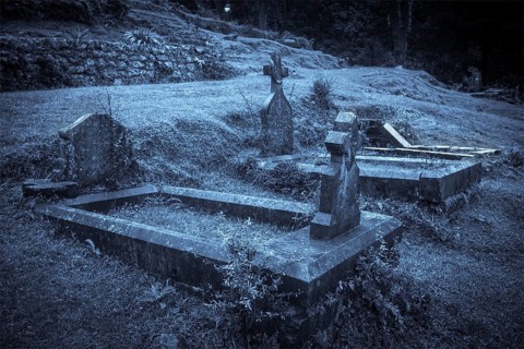 Spooky Halloween graveyard in fog in moonlight
