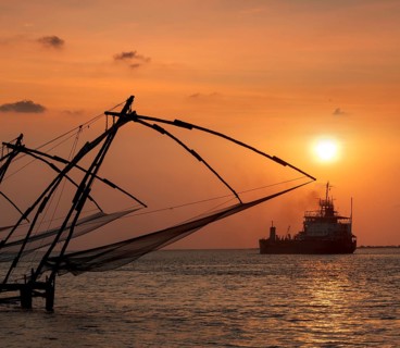 Kochi chinese fishnets on sunset and modern ship. Fort Kochin