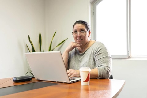Mature business woman sitting at head of table in office meeting room