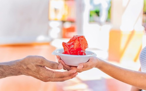 Two hands sharing a shaved ice in the street. Close up of two hands sharing a cup of shaved ice on the street. Concept of traditional Nicaraguan raspados. ICE SHAVING from Nagarote
