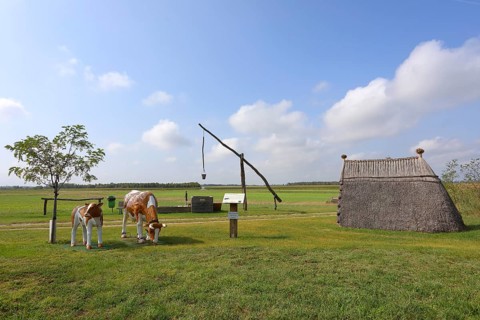 Drawing well and reed hut with cows sculpture