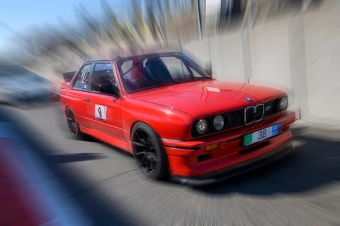 Dynamic photo with zoom effect of sports car racing car red BMW M3 S54 leaving pit lane