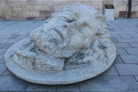 Large stone sculpture with the head of John the Baptist in front of St. John in Donaueschingen