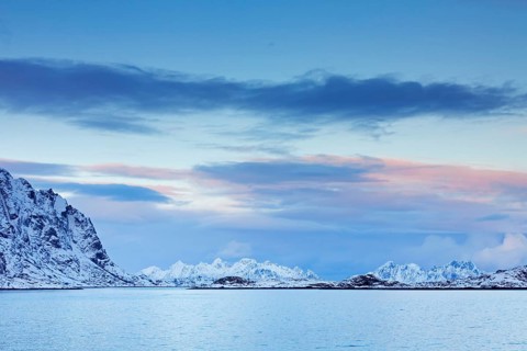 Mountains in the snow in winter by the fjord of Henningsvaer