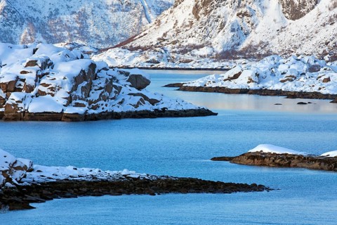 Mountains in the snow in winter by the fjord of Henningsvaer