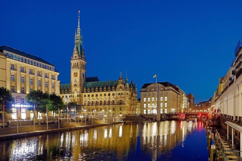 Illuminated City Hall with Little Alster and Alsterarkarden in the evening