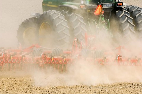 Close-up of tractor pulling harrows