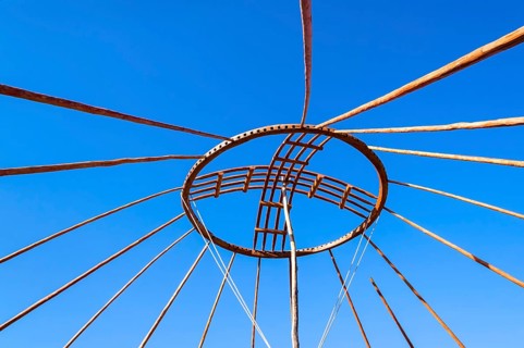 Kazakh men erecting the roof of a yurt