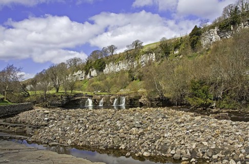 View of a river with waterfalls and limestone cliffs Wainwath Force and Cotterby Scar