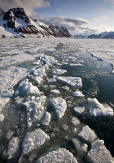 View of melting pack ice snow covered coastal mountains