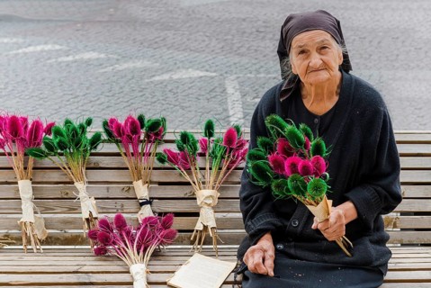 Georgian woman selling flowers on a bench
