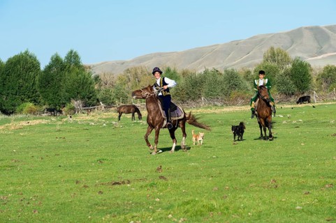 Two Kazakh horsemen in traditional dress