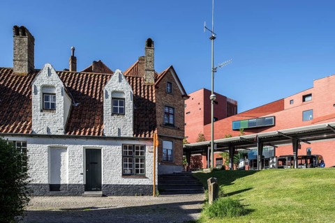 Medieval poorhouse and bus station in front of the concert hall in Bruges