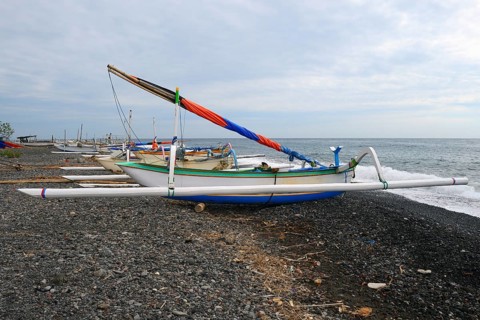 Traditional colourful outrigger boats on the black lava beach of Lovina