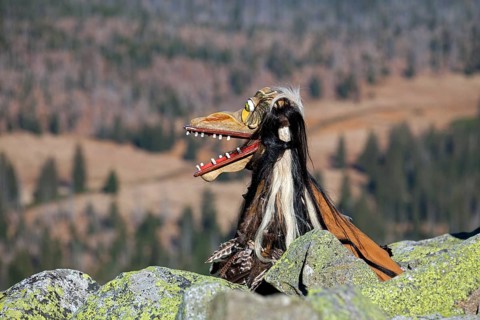 Creepy wooden devil figure on the summit of the Lusen in autumn