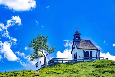 Hikers in front of the Postalm Chapel